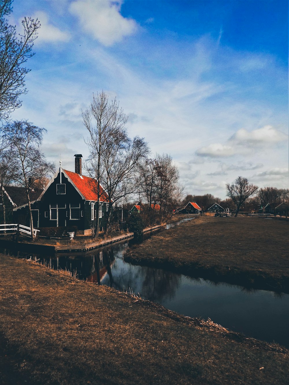 black houses with red roofs under blue cloudy sky