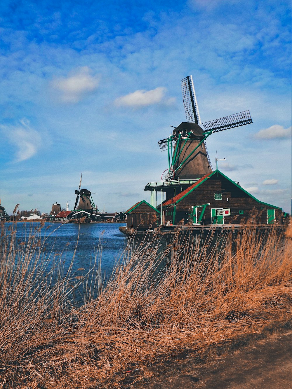 green and brown windmill under blue cloudy sy