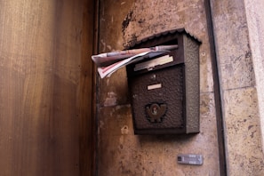 A sleek modern wooden mailbox featuring clean lines and a smooth finish against a brick wall