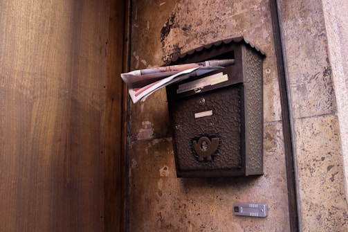 An inviting vintage steampunk mailbox with gears and glowing crystals in a post-apocalyptic setting.