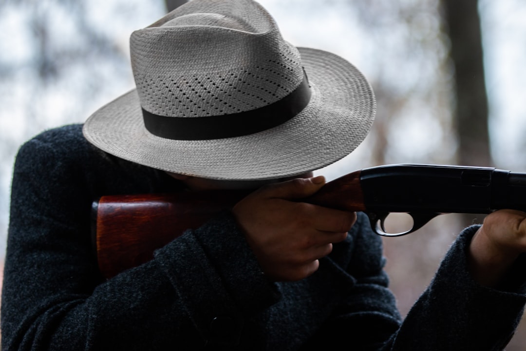 shallow focus photo of person holding rifle