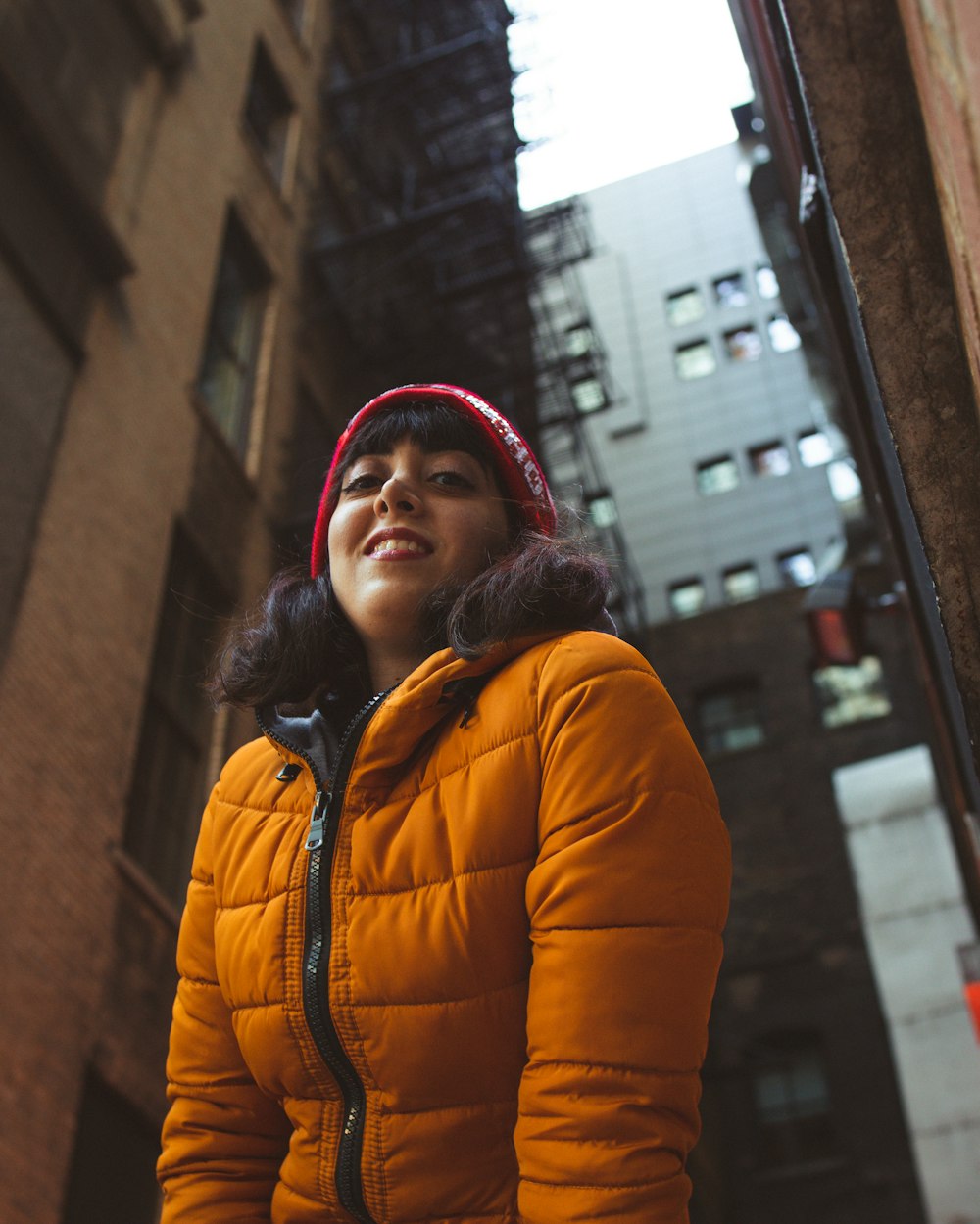 shallow focus photo of woman in orange full-zip bubble jacket