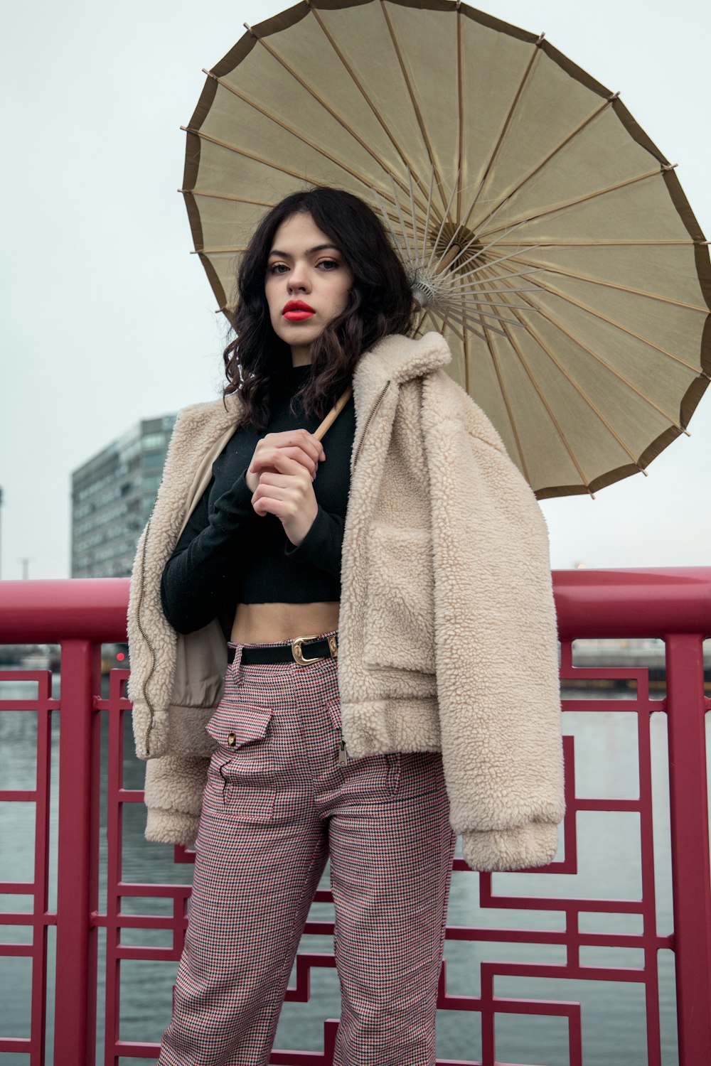 shallow focus photo of woman in black long-sleeved shirt holding gray umbrella