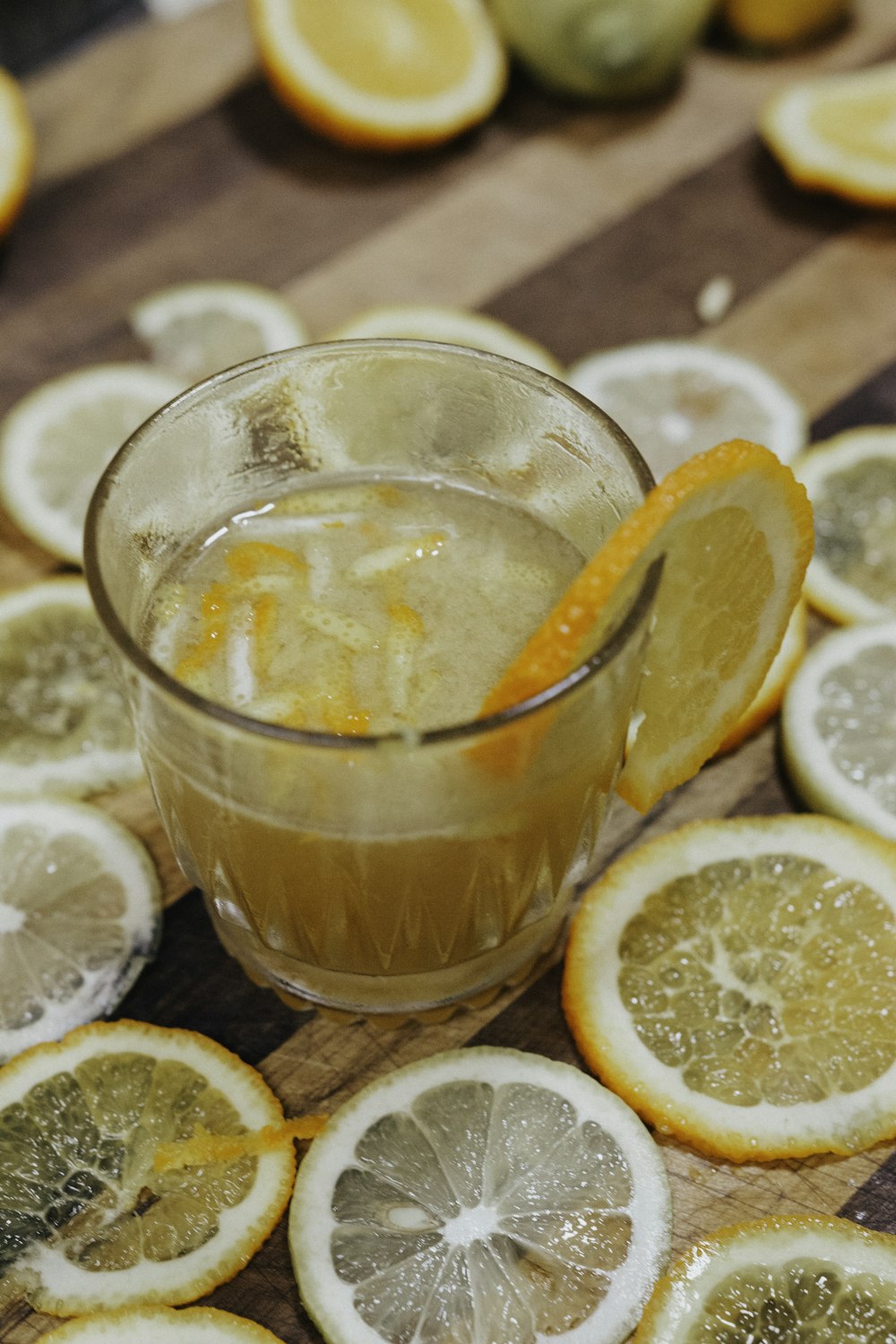 full drinking glass surrounded with lemon slices