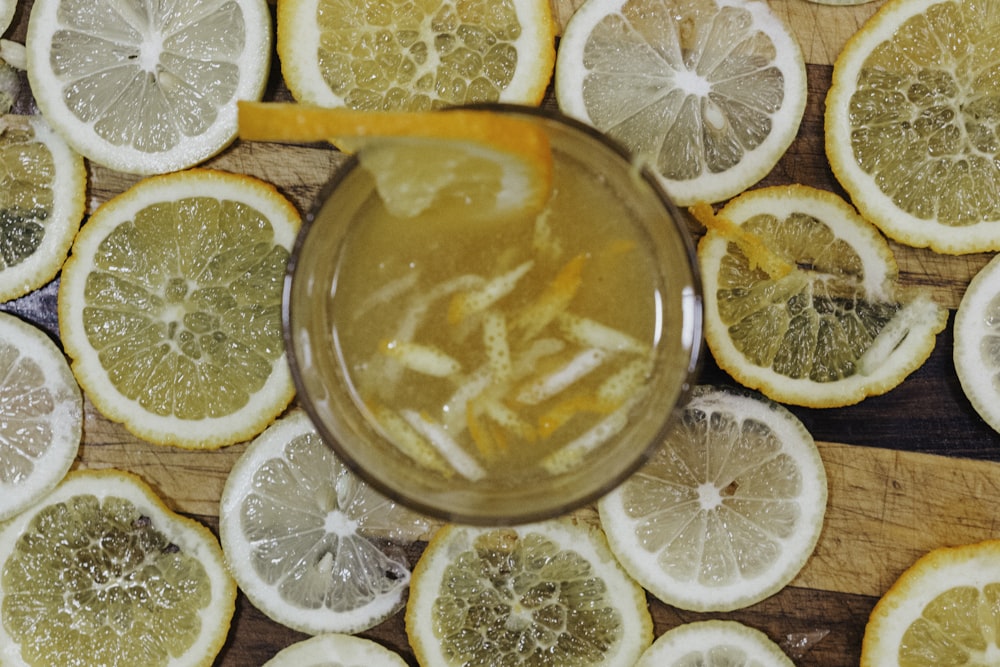 full drinking glass surrounded with lemon slices