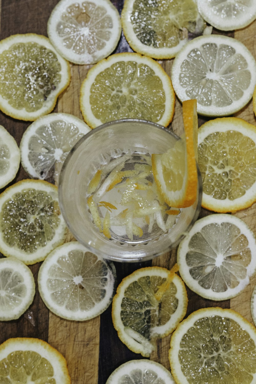 empty drinking glass surrounded with lemon slices