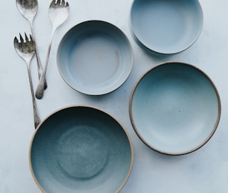 four assorted blue plates on white surface