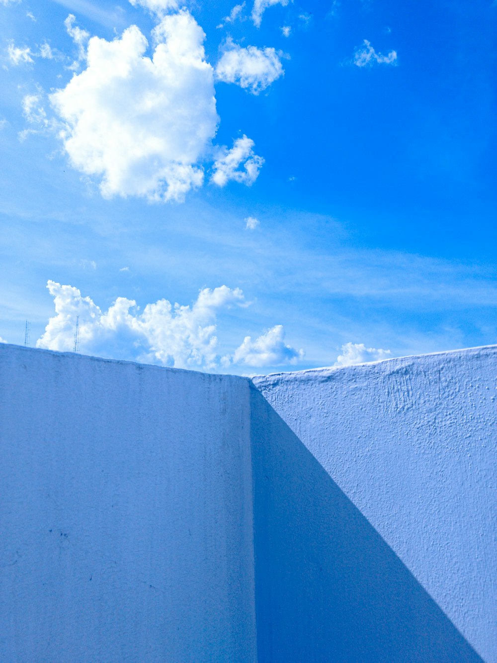 white-painted wall under blue cloudy sky