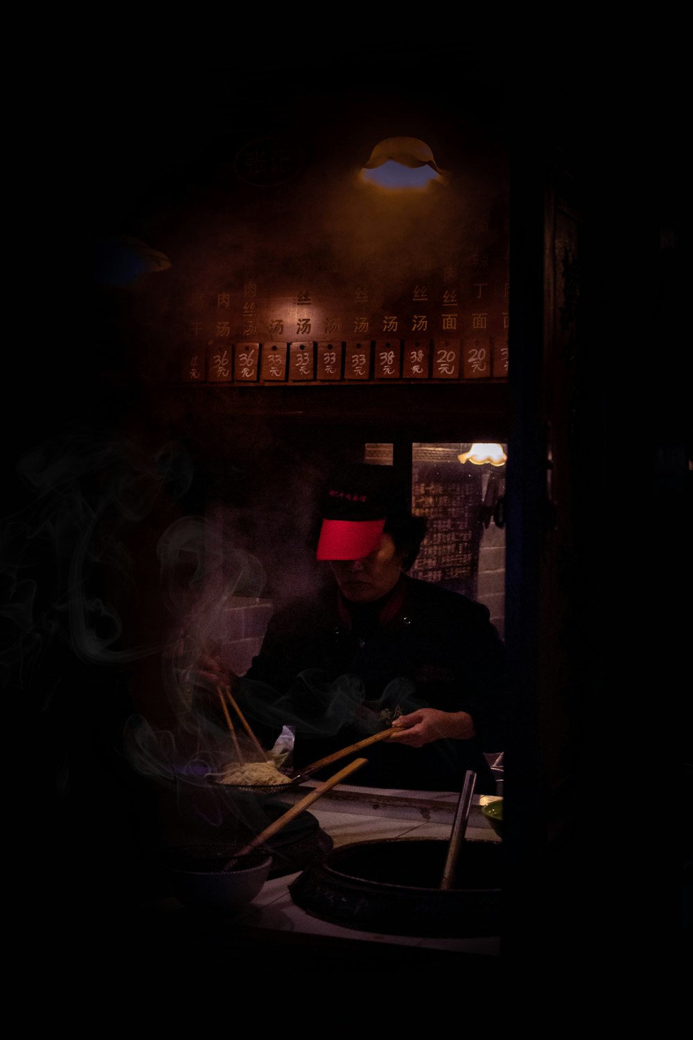 a man cooking food in a dark kitchen