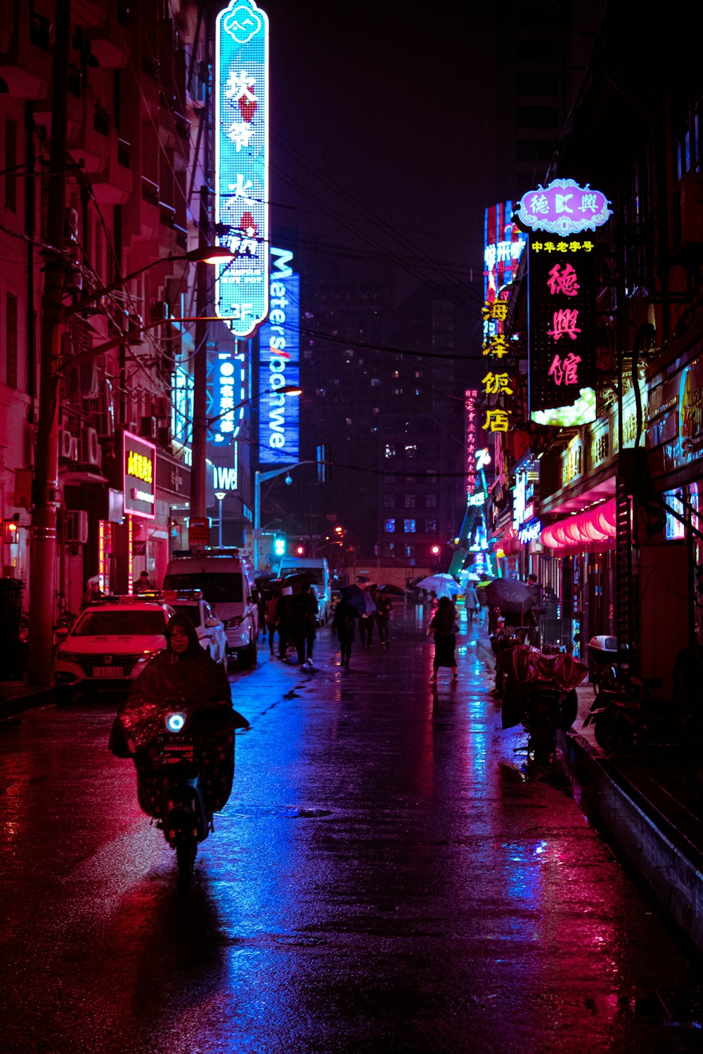 man riding motorcycle on street between buildings