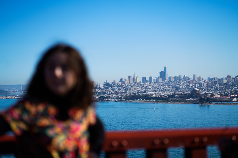 woman leaning on balustrade with cityscape background