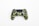 A gaming controller designed with a green camouflage pattern. The controller features various buttons, including analog sticks, a D-pad, and action buttons with recognizable PlayStation symbols. Its sleek design is set against a plain white background.