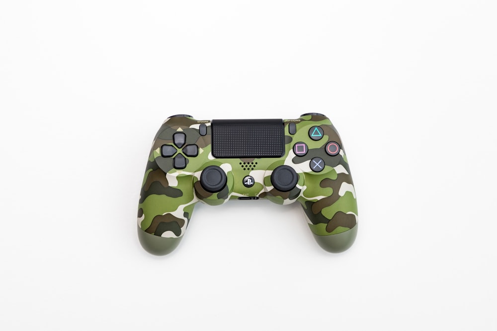 Green, black, and white camouflage Sony DualShock 4 wireless controller  photo – Free Shock Image on Unsplash