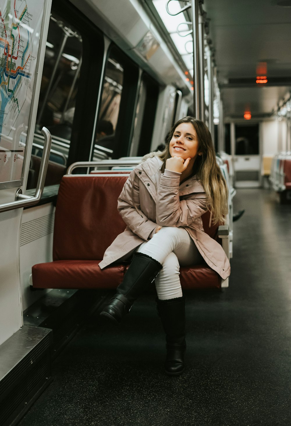 woman in coat sitting on train bench
