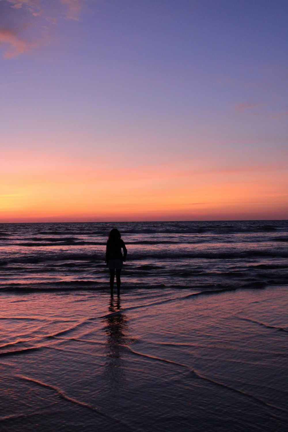 silhouette of person on seashore during daytime