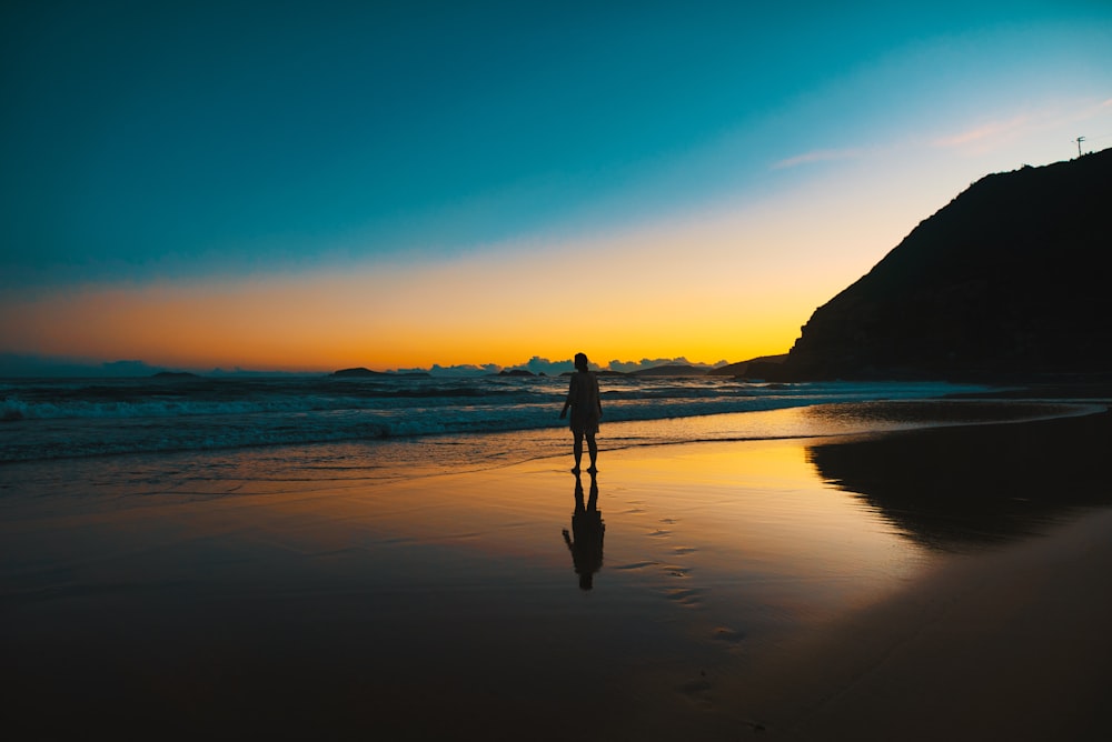 silhouette of person on seashore during daytime