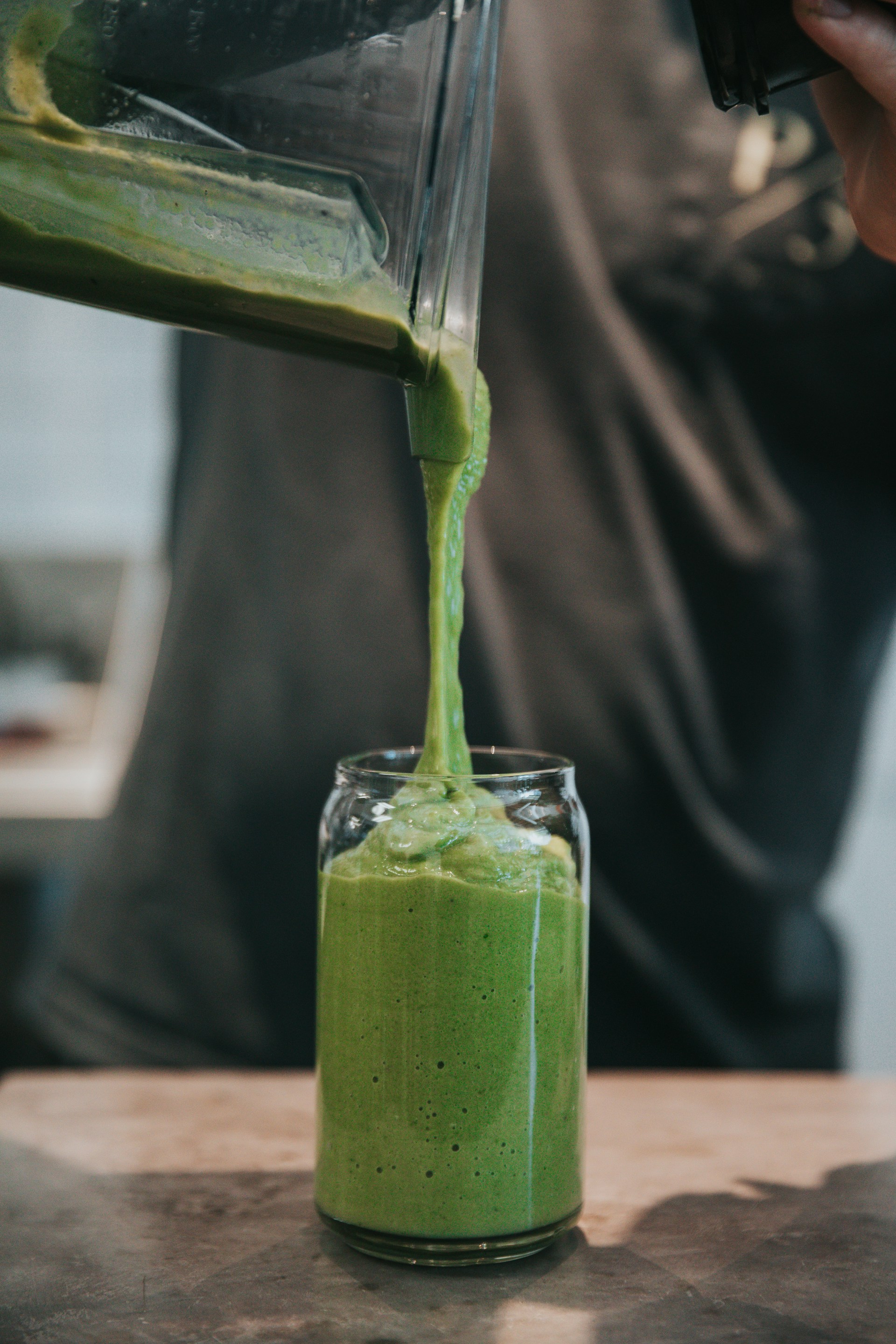 person pouring cream in drinking glass