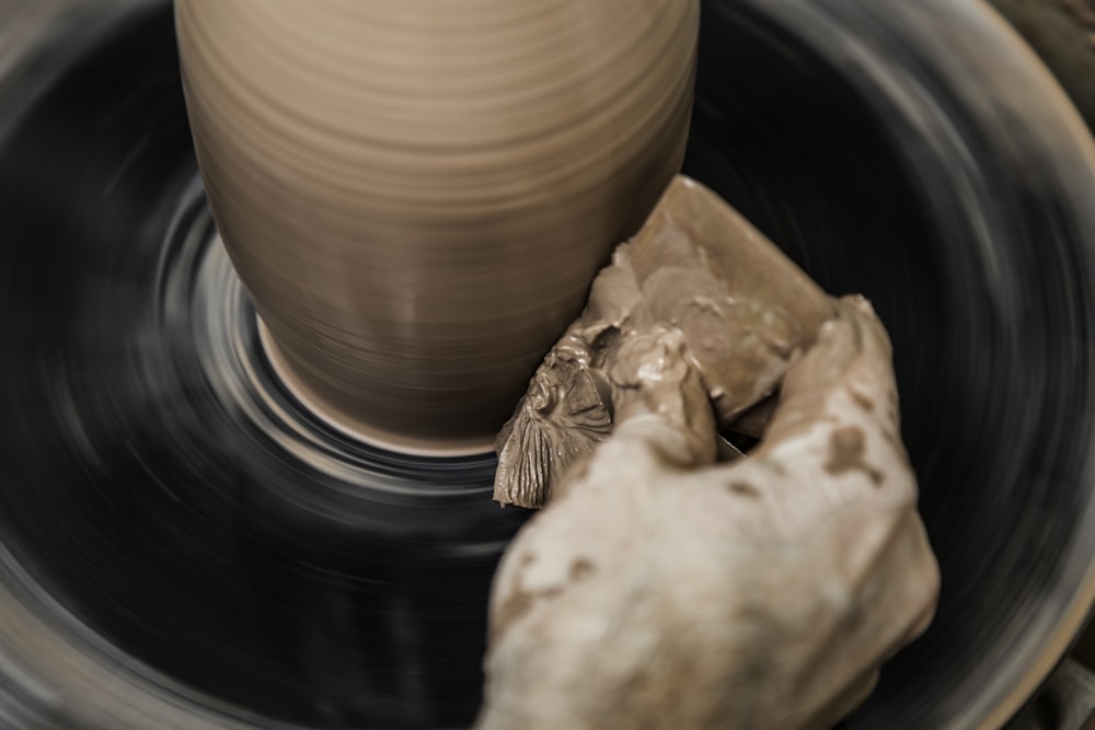 person making a clay vase on spinning tale