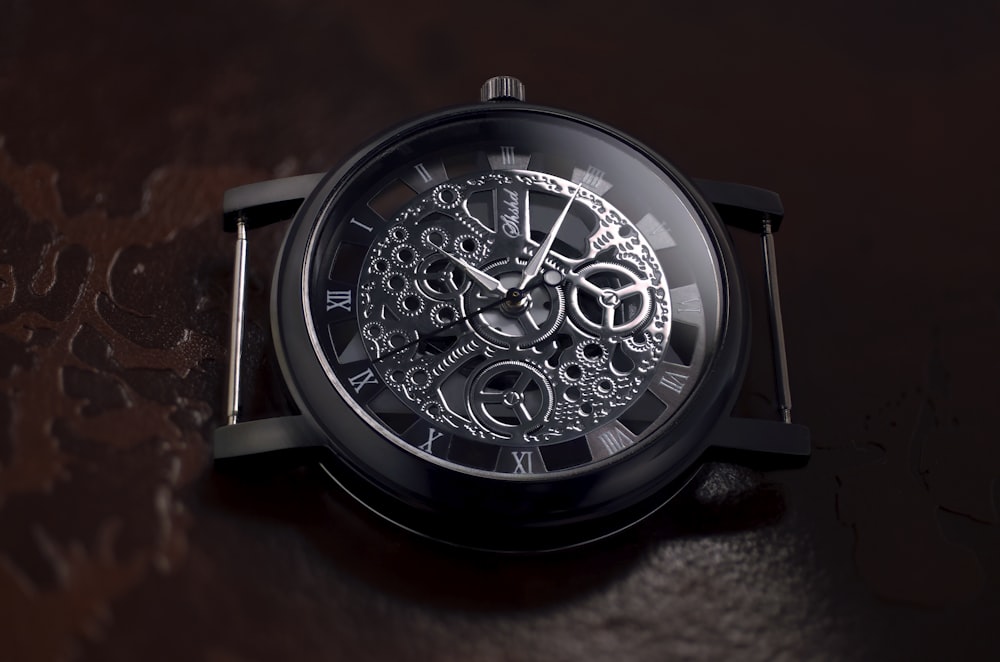 round black and gray skeletal watch