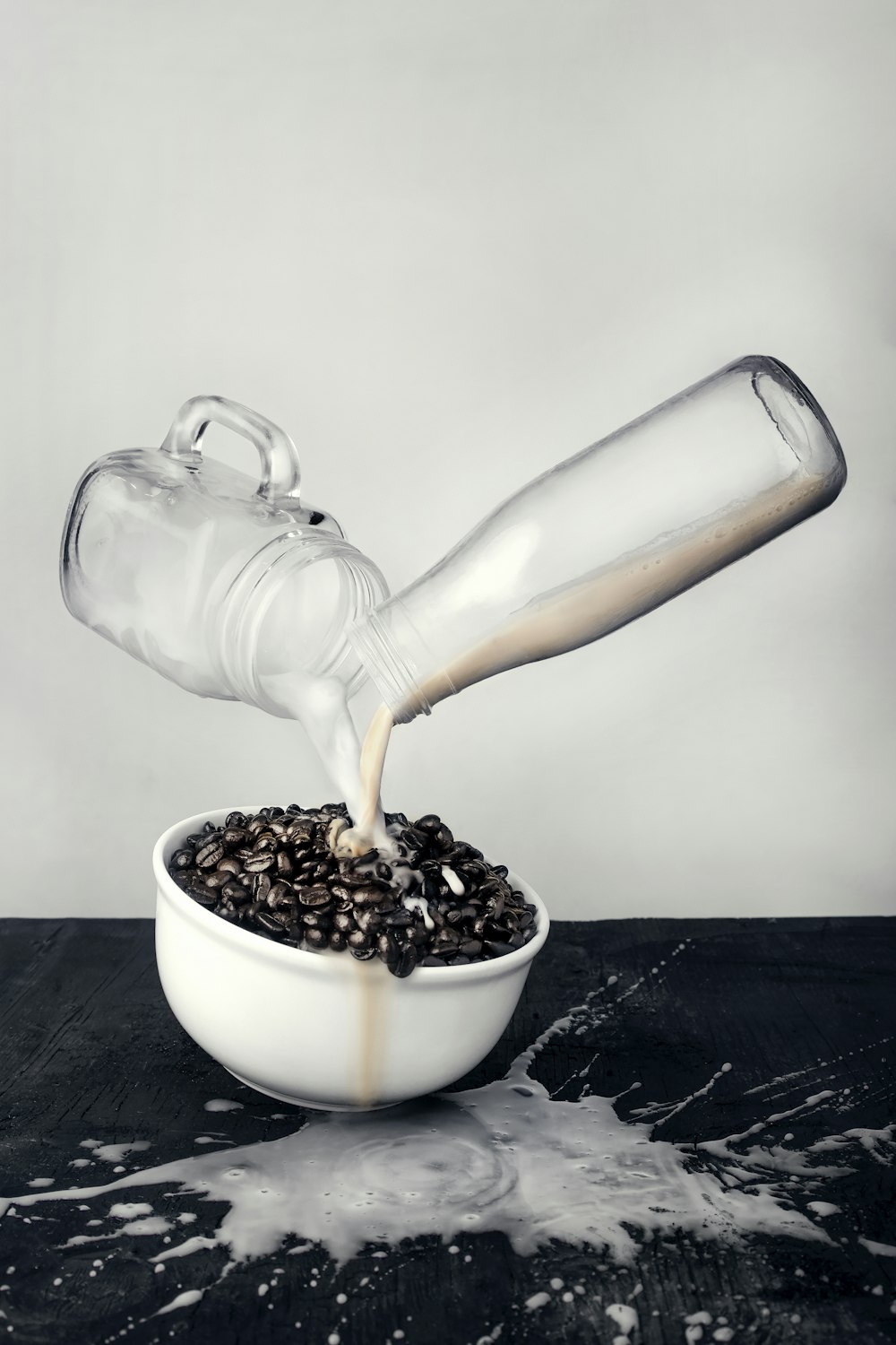 glass bottle and mug jar pouring milk in bowl full of coffee beans