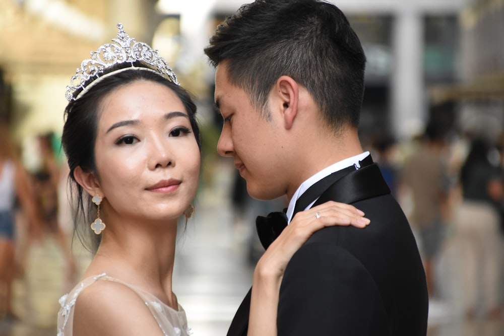 woman wearing tiara placng hand on man's left shoulder