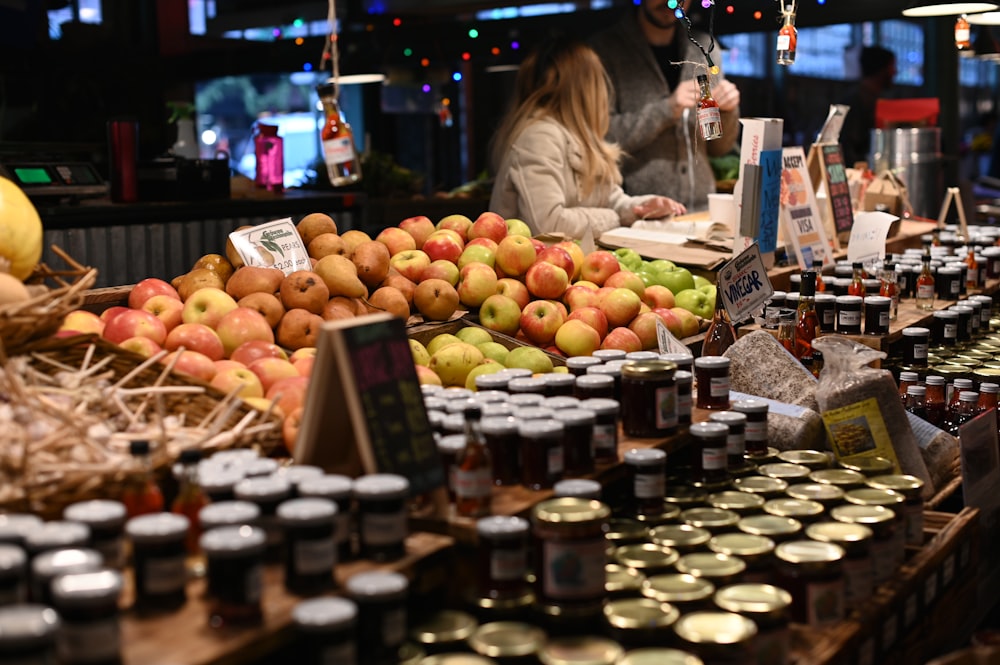 pile of apples in basket beside jars