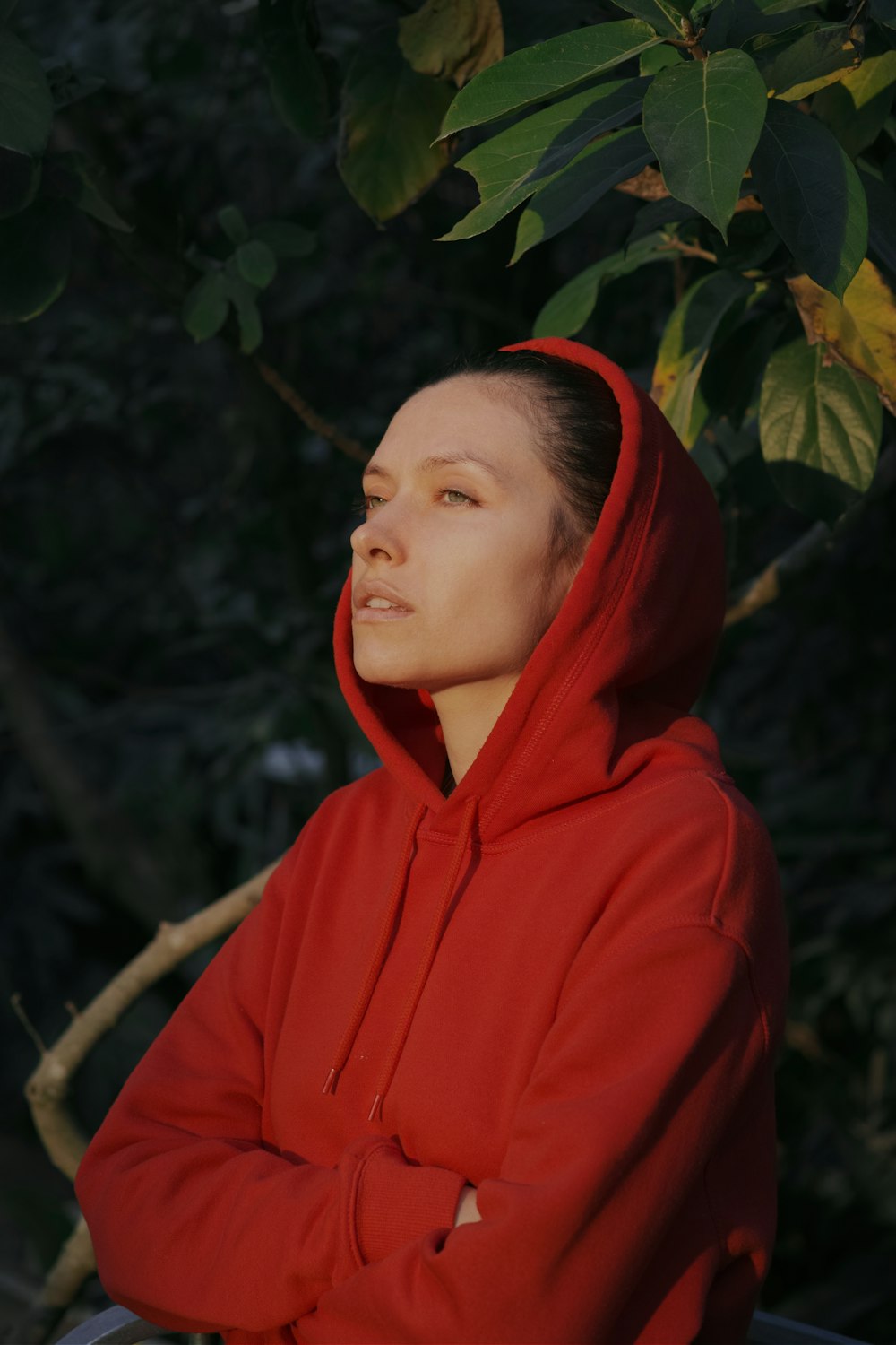 Frau im roten Kapuzenpullover mit Blick auf das Sonnenlicht