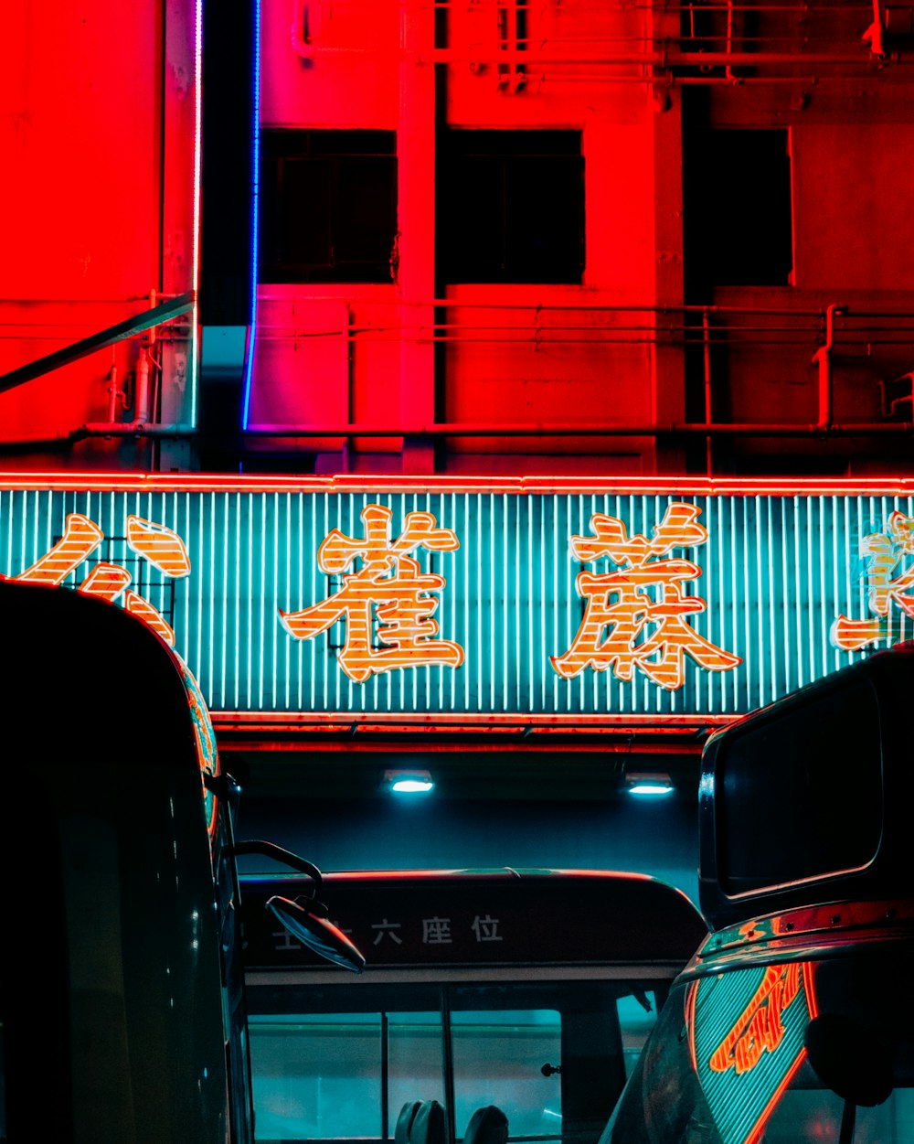 LED kanji script sign turned on on building near vehicles during night