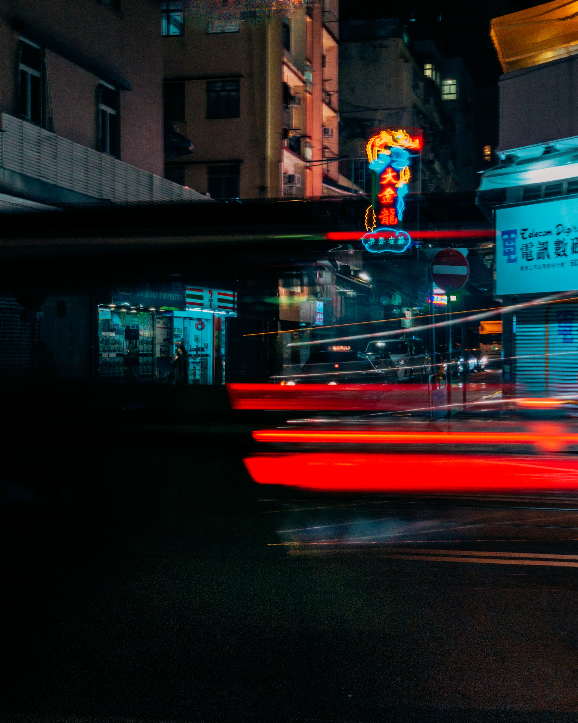 Nighttime cityscape with glowing street signs and colorful abstract shapes blending into the dark city streets.