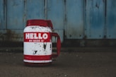 selective focus photography of white and red Hello printed bottle