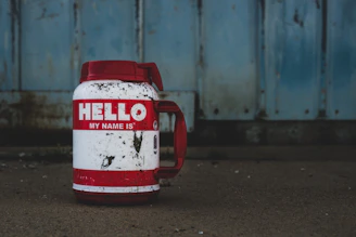 selective focus photography of white and red Hello printed bottle