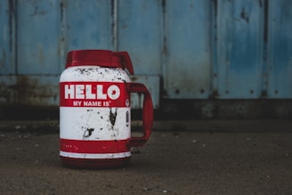 selective focus photography of white and red Hello printed bottle