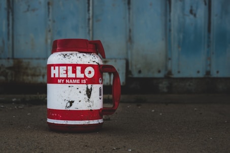 selective focus photography of white and red Hello printed bottle
