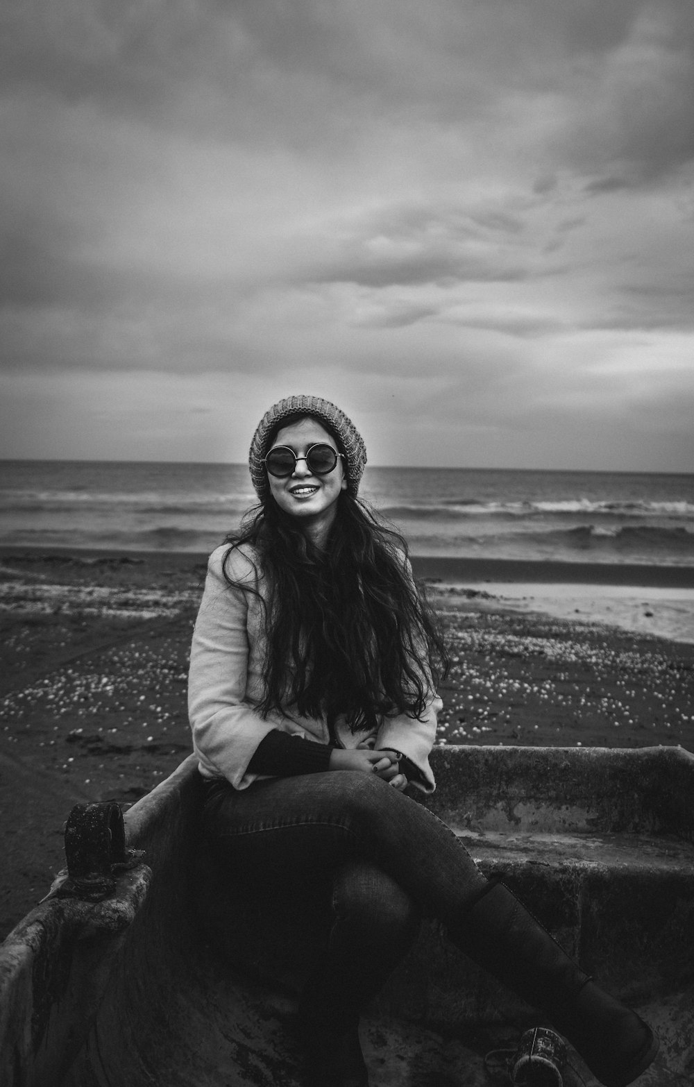 Photographie en niveaux de gris d’une femme assise sur un bateau