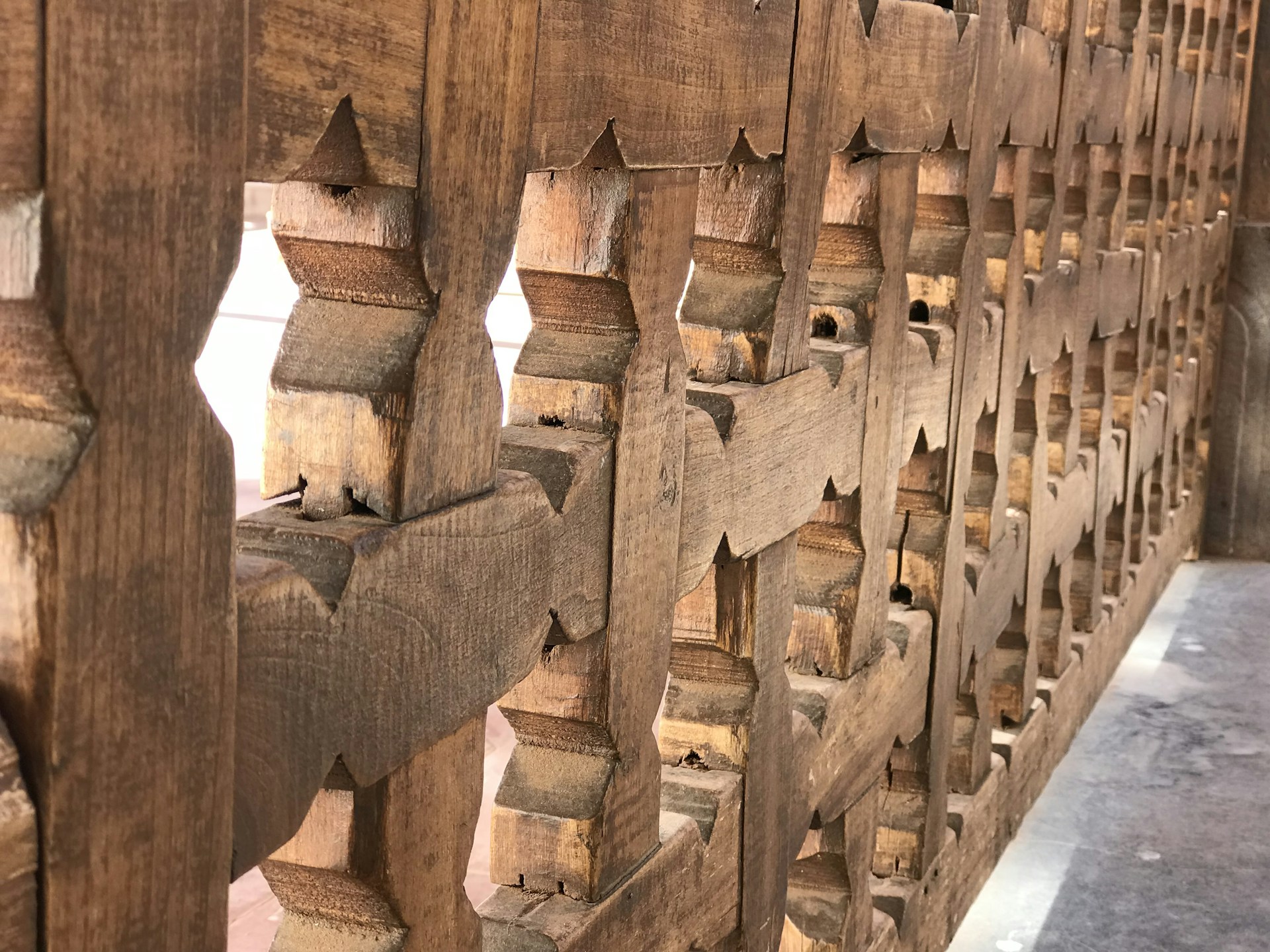 A close-up shot of a finely detailed wooden wall art piece with geometric patterns, softly lit to highlight the precision of the CO2 laser cuts.