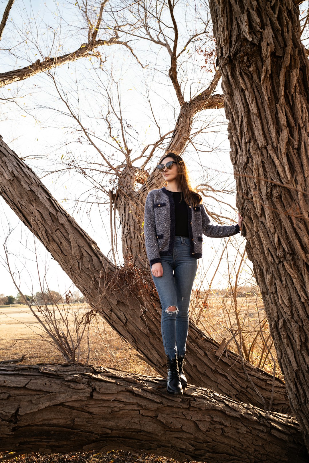 woman standing on tree branch during day