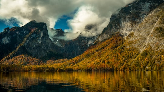 mountains near body of water under cloudy sky in Königsee Germany