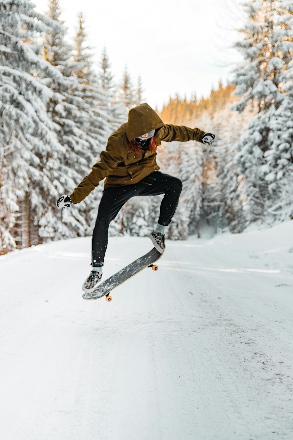 Mann macht im Winter Tricks auf einem Skateboard in der Luft