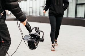 shallow focus photo of person holding black video camera