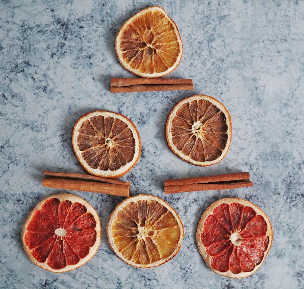 sliced grapefruit near three cinnamon