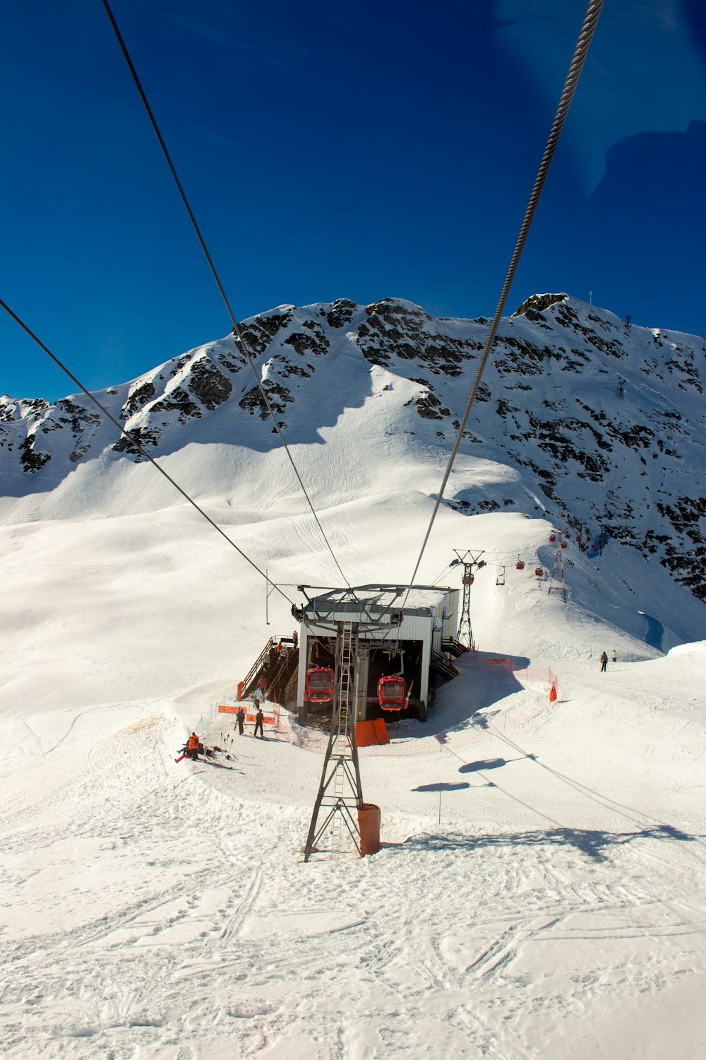 téléphérique dans une montagne enneigée sous un ciel bleu calme pendant la journée