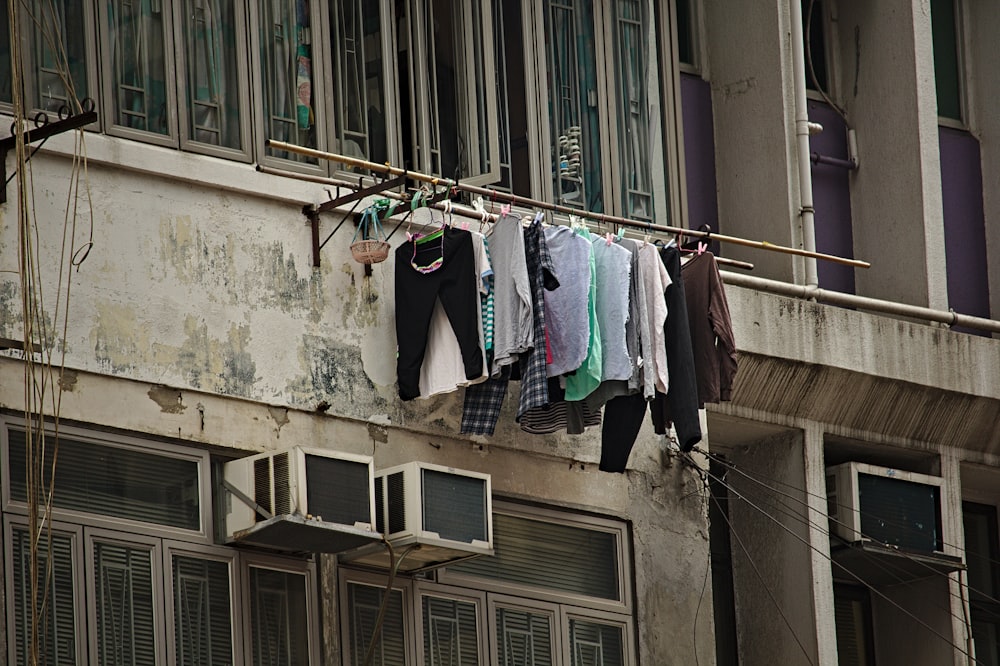 assorted clothes hanging beside building