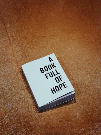 A single book with a cover displaying the words 'A Book Full of Hope' lies on a textured brown surface.