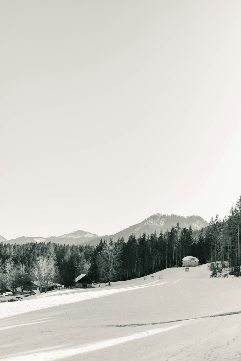 house and field covered with snow viewing mountain