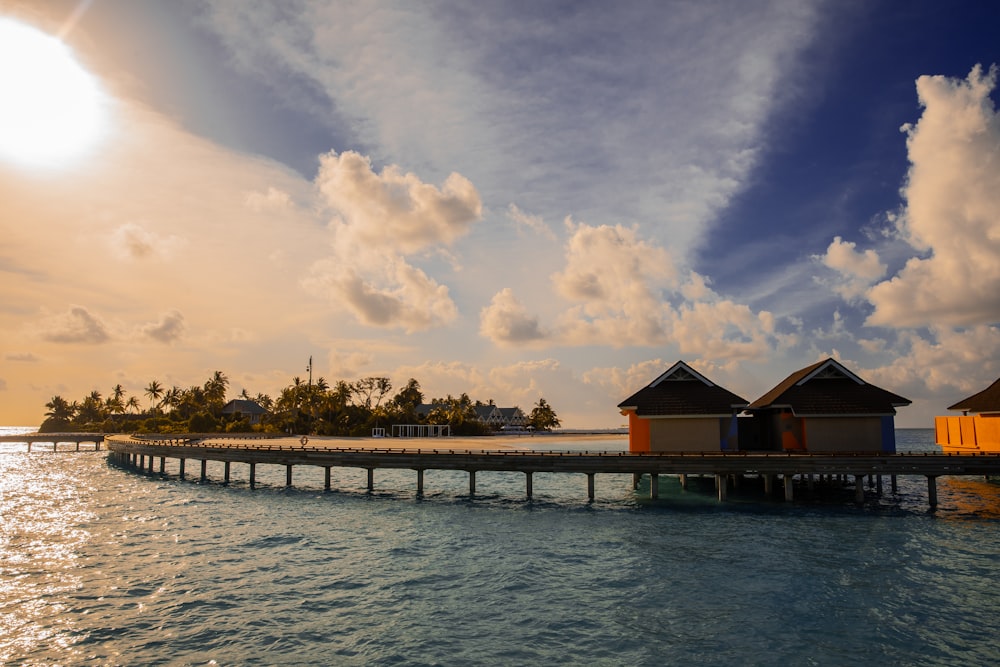 a pier with houses on it in the middle of the ocean