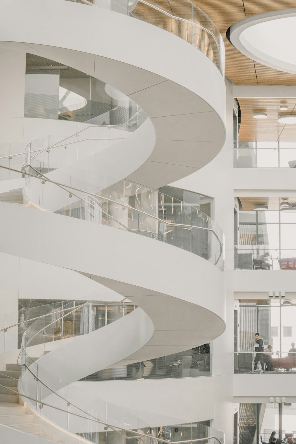 a spiral staircase in a building with people walking around