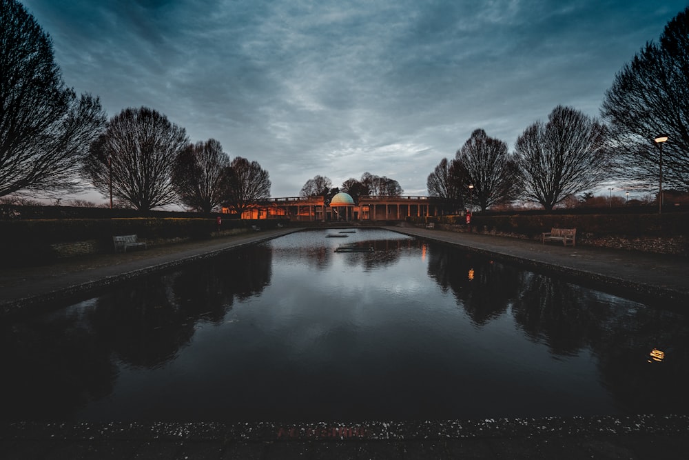 a pond with a building in the background