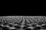 Close-up of a single sheet of graphene on a futuristic industrial background.