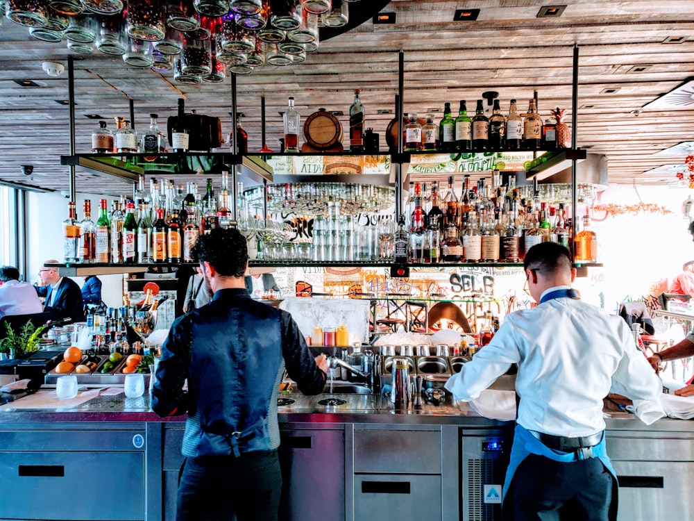dois homens em pé perto da mesa dentro do bar