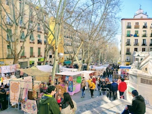A vibrant street market bustling with colorful stalls under a deep blue sky